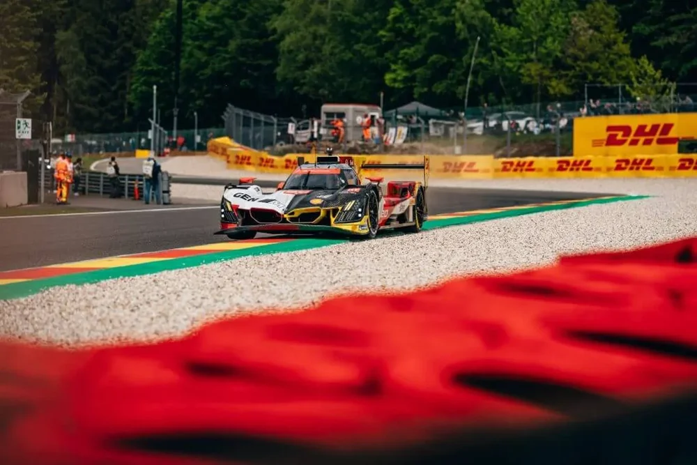 The #20 BMW car on its way to victory in the 2026 6 Hours of Spa-Francorchamps. Trees line the background of the image, with gravel and a tire barrier in the foreground.
